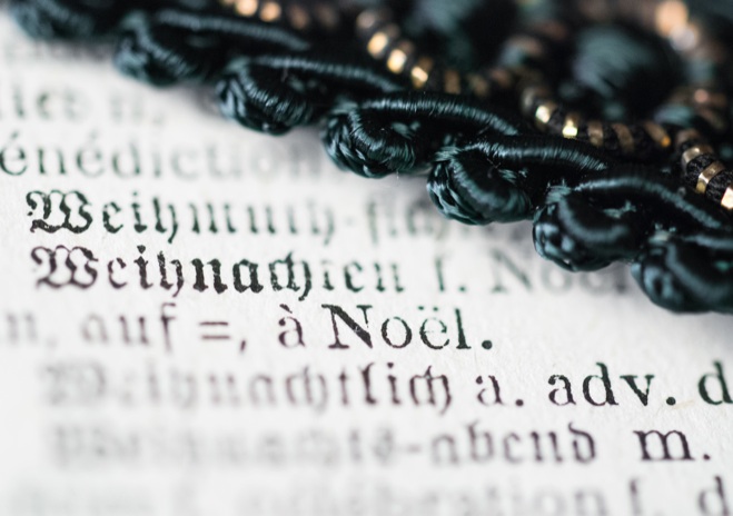 D0013 - Auszug aus einem Wörterbuch über welchem eine Kordel liegt.